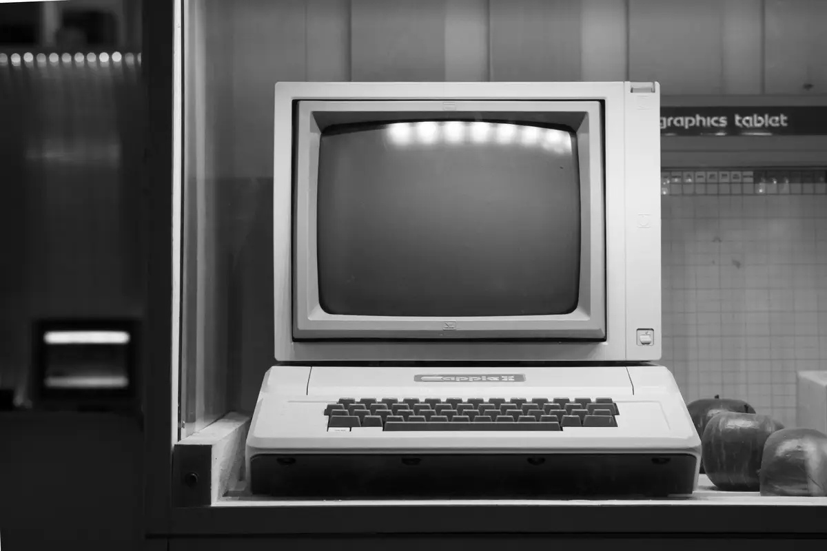 An early desktop computer behind glass, black and white